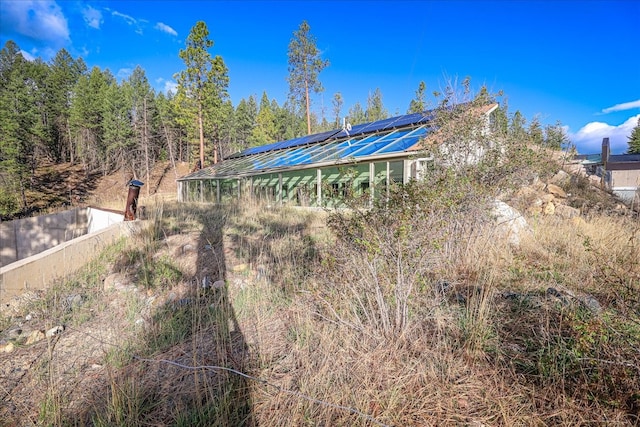 rear view of property featuring solar panels