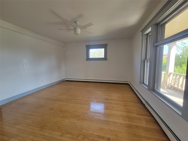 spare room with ceiling fan, a baseboard radiator, and light hardwood / wood-style flooring