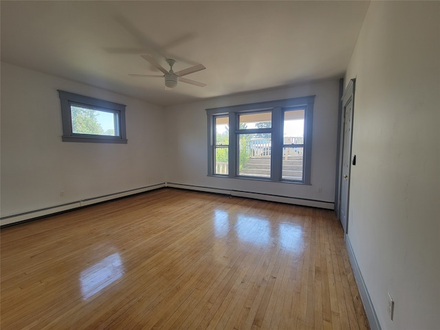 unfurnished room with light wood-type flooring, baseboard heating, ceiling fan, and plenty of natural light