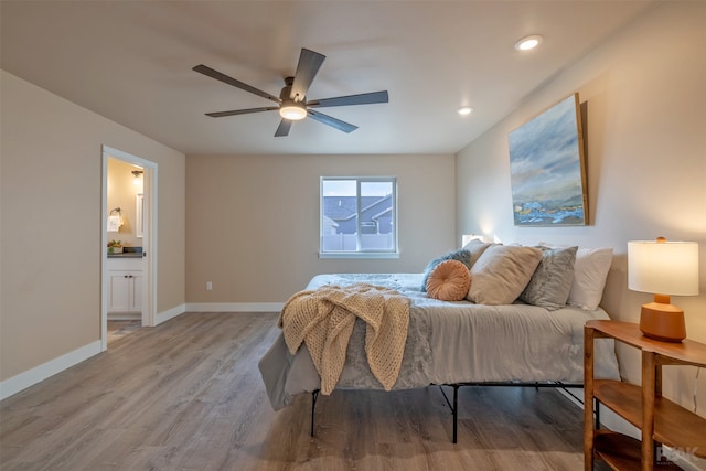 bedroom with light hardwood / wood-style flooring, ensuite bathroom, and ceiling fan