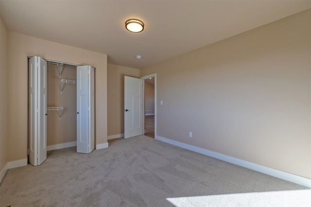 unfurnished bedroom featuring light carpet and a closet