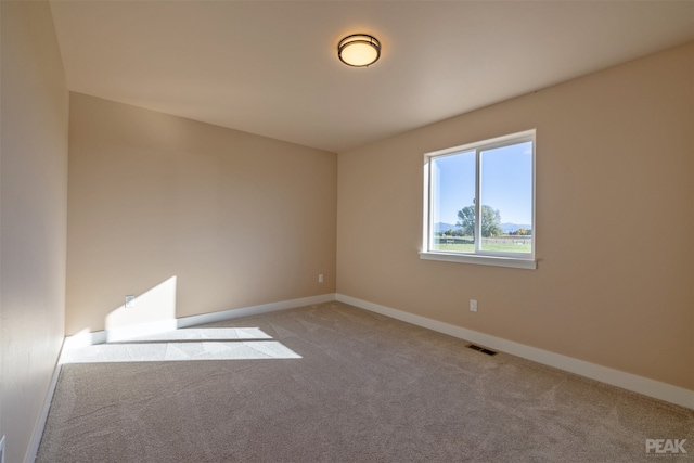 unfurnished room featuring light colored carpet