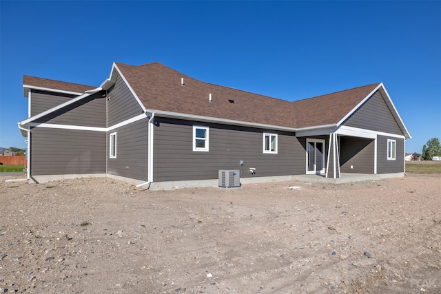 rear view of property with central AC