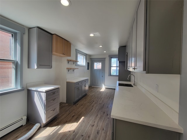 kitchen featuring a baseboard radiator, gray cabinetry, dark wood-type flooring, and sink