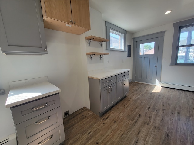 kitchen featuring gray cabinetry, a baseboard heating unit, and dark wood-type flooring