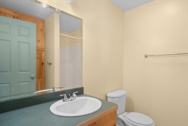 bathroom with walk in shower, vanity, and toilet