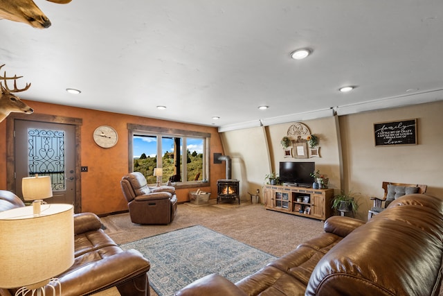 living room featuring a wood stove and carpet floors