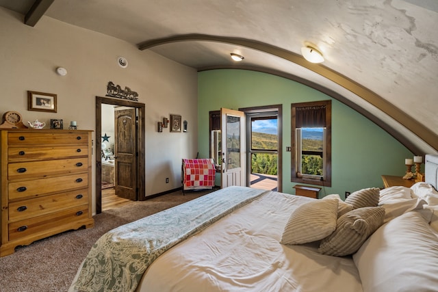 bedroom featuring access to outside, lofted ceiling with beams, and dark colored carpet