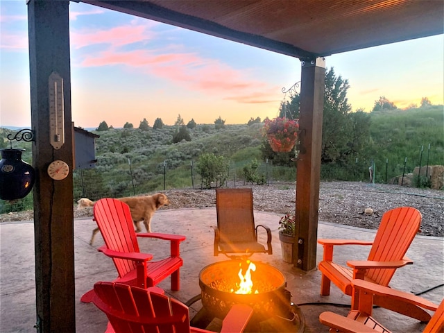 patio terrace at dusk featuring an outdoor fire pit