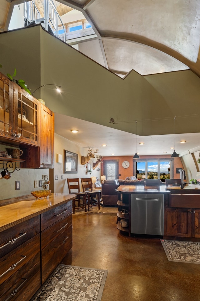 kitchen with backsplash, a skylight, sink, and stainless steel dishwasher