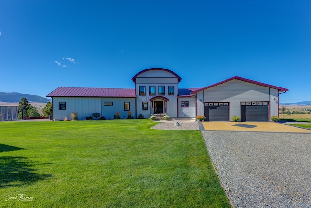 view of front facade with a garage, a mountain view, and a front yard