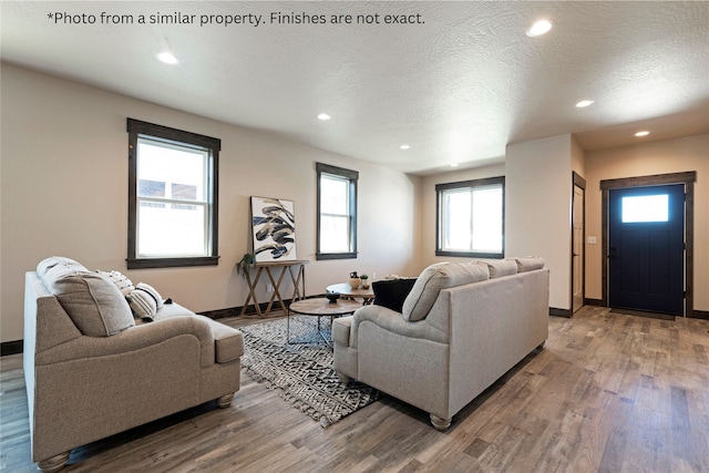 living room with a textured ceiling, hardwood / wood-style floors, and a wealth of natural light