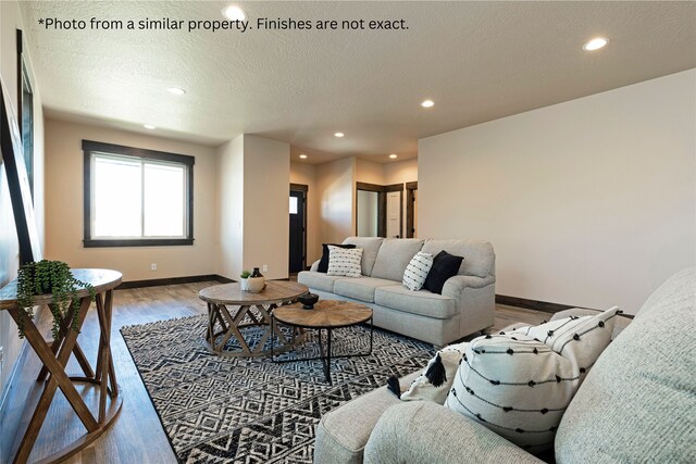 living room featuring a textured ceiling and hardwood / wood-style floors