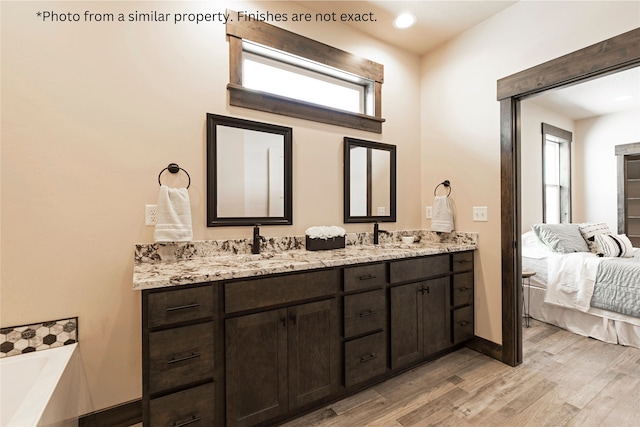 bathroom with a bathtub, vanity, and hardwood / wood-style flooring