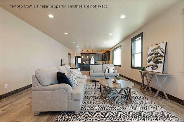 living room with a textured ceiling and light wood-type flooring