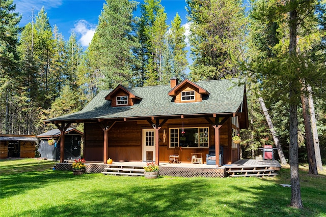 rear view of house featuring a yard and a wooden deck