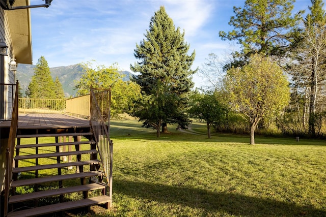 760 Trap Rd, Columbia Falls, MT 59912 - view of green lawn with a deck with mountain view and stairway