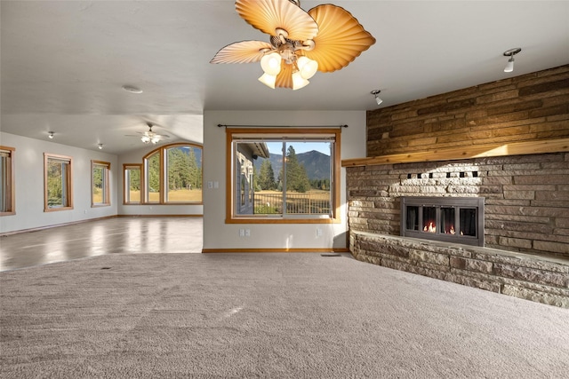 760 Trap Rd, Columbia Falls, MT 59912 - unfurnished living room featuring a fireplace, a ceiling fan, and carpet