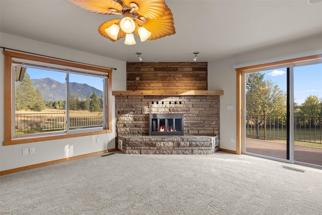 760 Trap Rd, Columbia Falls, MT 59912 - unfurnished living room with carpet, a large fireplace, and plenty of natural light
