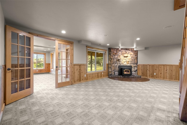 760 Trap Rd, Columbia Falls, MT 59912 - unfurnished living room with carpet, wainscoting, wood walls, recessed lighting, and french doors