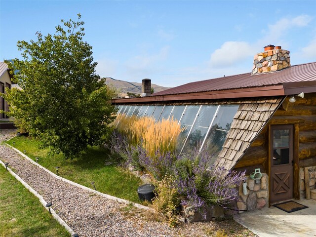 view of property exterior with a chimney and metal roof
