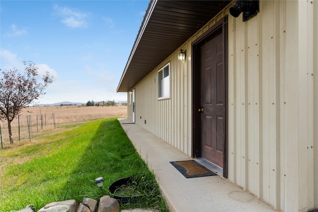 view of exterior entry featuring a yard and a rural view