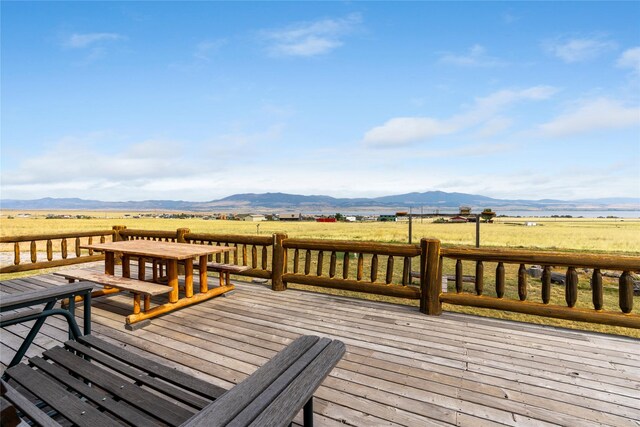 deck with a rural view and a mountain view