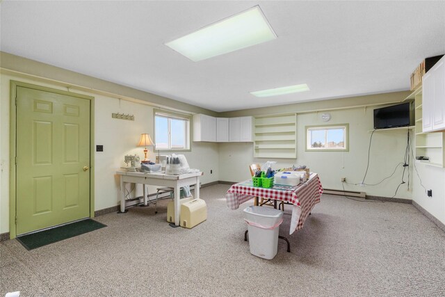 recreation room with a baseboard heating unit, baseboards, and light colored carpet