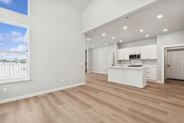 304 Trailview Way, Whitefish, MT 59937 - kitchen with stainless steel microwave, light wood-type flooring, white cabinetry, light countertops, and recessed lighting