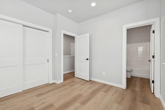 304 Trailview Way, Whitefish, MT 59937 - unfurnished bedroom featuring a closet, light wood-style flooring, ensuite bath, and recessed lighting