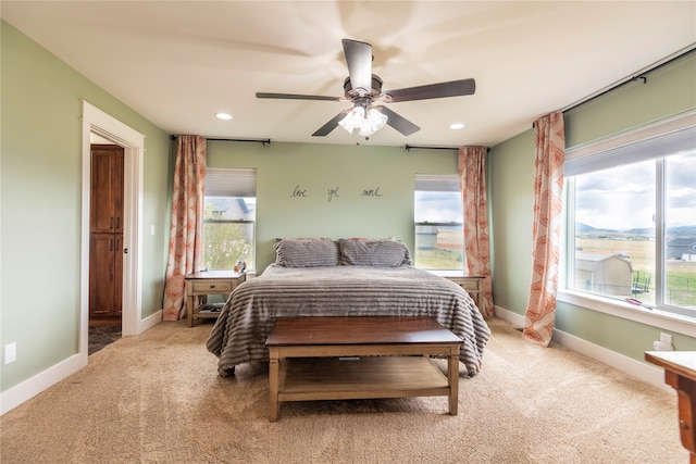 bedroom featuring multiple windows, ceiling fan, and carpet floors