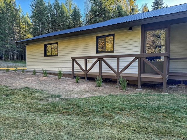 exterior space featuring a lawn and metal roof