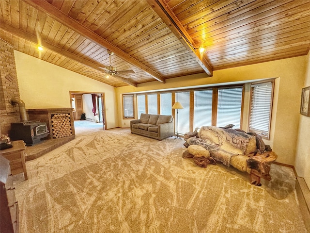 living room with lofted ceiling with beams, wooden ceiling, ceiling fan, a wood stove, and carpet flooring