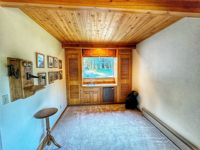 unfurnished room featuring a baseboard heating unit, wooden ceiling, light colored carpet, and baseboards