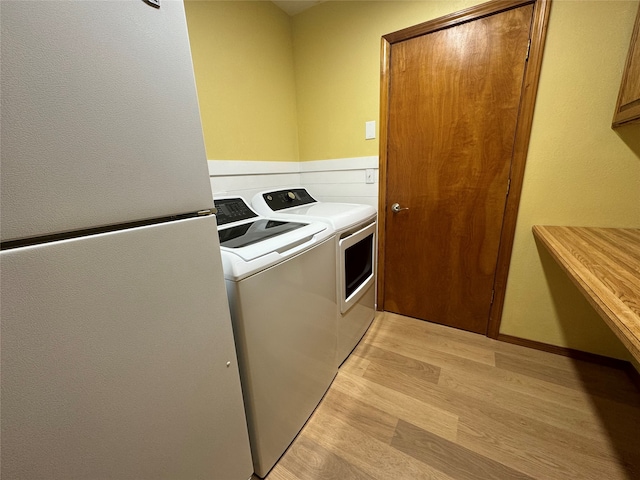 laundry room featuring laundry area, light wood finished floors, and washer and clothes dryer