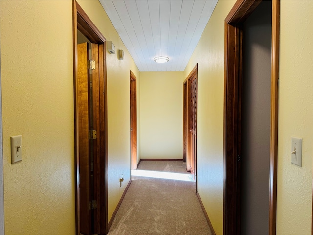 corridor with carpet and baseboards