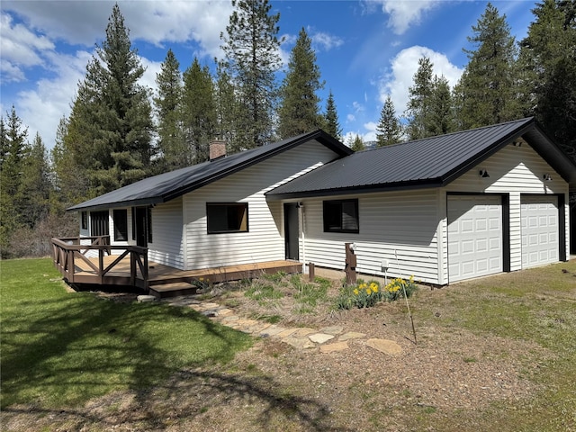 view of front of house featuring a wooden deck, a chimney, a front yard, and metal roof
