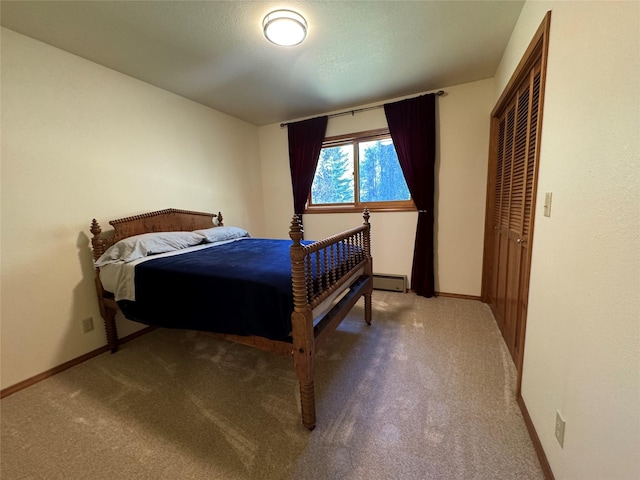 bedroom featuring a baseboard heating unit, baseboards, carpet flooring, and a closet