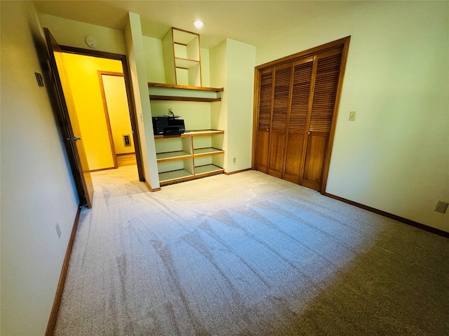 unfurnished bedroom featuring light colored carpet, baseboards, and a closet