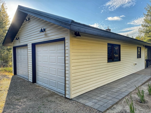 view of side of home with an outdoor structure and a detached garage