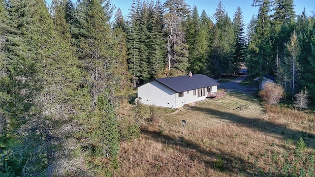 birds eye view of property featuring a forest view