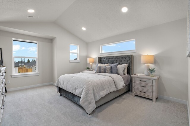 bedroom with lofted ceiling and light colored carpet