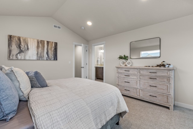 carpeted bedroom featuring lofted ceiling and connected bathroom