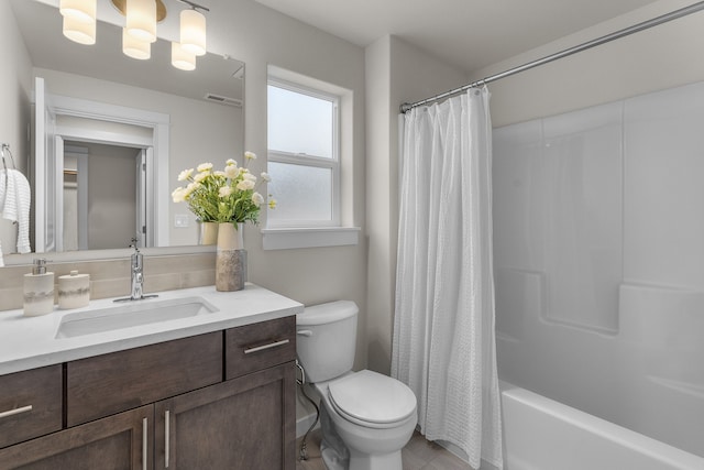 full bathroom featuring shower / bath combo with shower curtain, tile patterned floors, vanity, and toilet