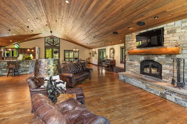 living room with vaulted ceiling, a fireplace, hardwood / wood-style floors, and wood ceiling