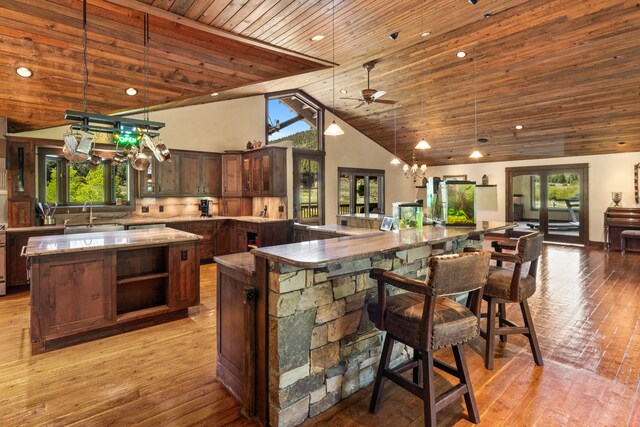 kitchen with high vaulted ceiling, a large island, wooden ceiling, and a wealth of natural light