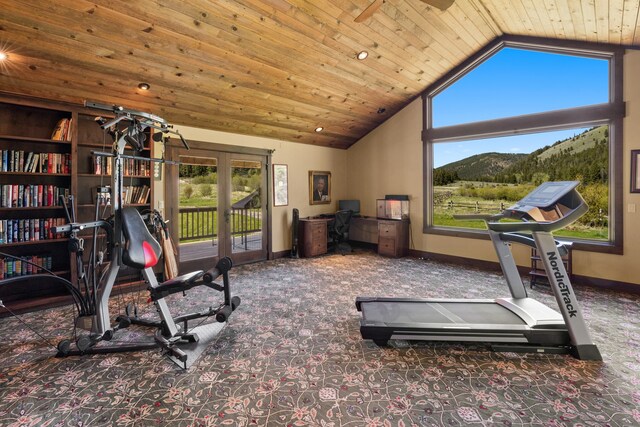 exercise area with wood ceiling, a mountain view, and a healthy amount of sunlight