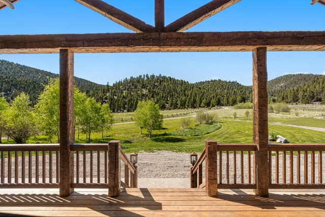 wooden deck with a lawn and a mountain view