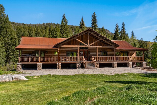 log cabin with a deck and a front yard