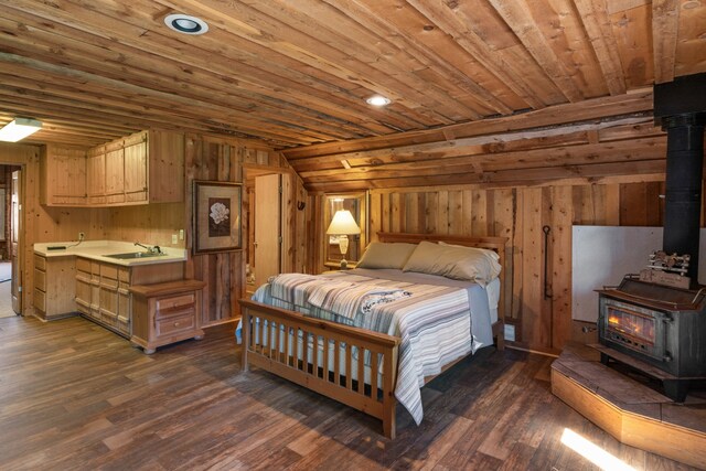 bedroom with a wood stove, wooden ceiling, and dark wood-type flooring